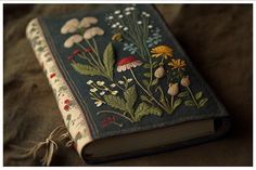 an old book is decorated with flowers and leaves