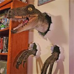 a dinosaur head mounted to the side of a book shelf next to an open bookcase