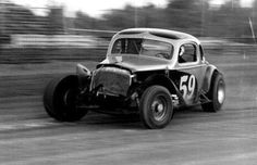 an old time race car driving down the track