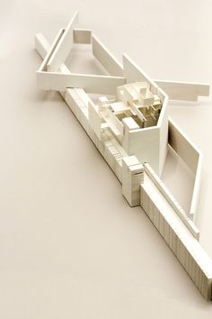 an architectural model of a building on a white surface with no people around it,