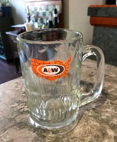 a glass mug sitting on top of a counter with a sticker in the middle