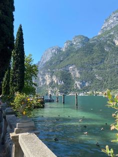 the water is crystal blue and clear with ducks swimming in it, near some mountains