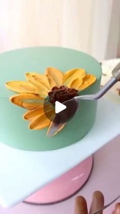 a person is cutting into a cake decorated with flowers and chocolate icing on top