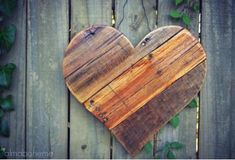 a heart shaped cutting board sitting on top of a wooden fence