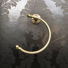 a gold door handle on a black and silver wallpapered room with damask