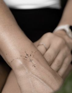 a woman's arm with a small star tattoo on the left side of her arm