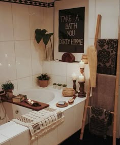 a bathroom with a bathtub, towel rack and candles on the counter next to it