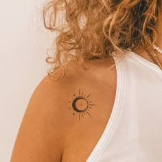 a woman with a sun and moon tattoo on her upper arm