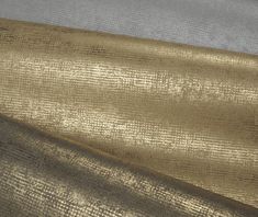 gold and white fabric with metallic foiling on the bottom, in shades of grey