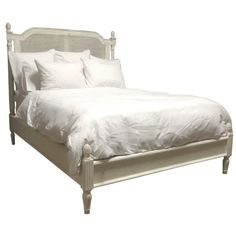 a bed with white sheets and pillows on it