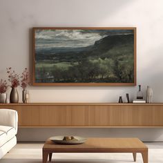 a painting hanging on the wall above a table in a living room with white furniture