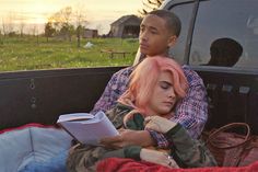 a man and woman sitting in the back of a pick up truck