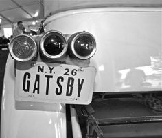 an old car with three lights and a sign on the front that says ny 26 gatsby