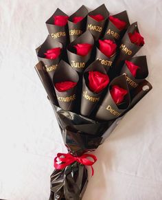 a bouquet of red roses wrapped in black paper