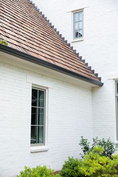 a white brick house with a red tiled roof