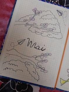 an open notebook with drawings on it and the word mai written in cursive writing