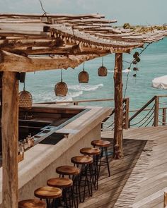 an outdoor bar overlooking the ocean with lots of stools