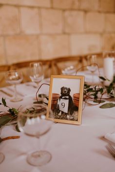 the table is set with white linens and greenery