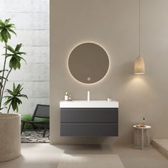 a white sink sitting under a round mirror next to a potted plant in a bathroom