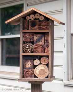 a bird house made out of wood with lots of holes in the front and sides