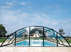 an empty swimming pool in the middle of a large open area with glass walls on each side