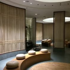 an empty room with round seating and bamboo screens