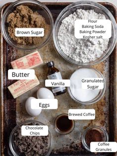 ingredients to make chocolate chip cookies laid out on a baking sheet, including flour, sugar, butter, and eggs