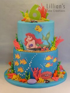 a three tiered cake decorated with an image of the little mermaid