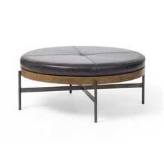 a black leather ottoman sitting on top of a metal frame