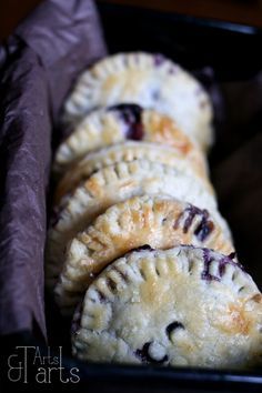 four blueberry hand pies in a black dish