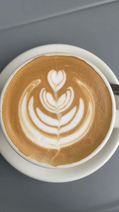 a cappuccino in a white cup on a saucer