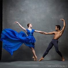 a man and woman are dancing together in the studio with their arms spread out to each other