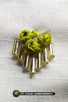 four yellow and silver hair clips sitting on top of a white cloth