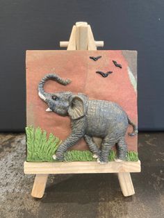 an elephant painted on top of a wooden easel