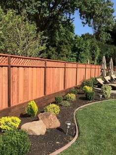 a wooden fence next to a lush green yard