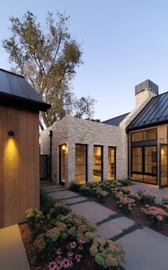 an exterior view of a modern home with stone and wood