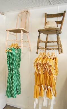 two wooden chairs hanging from hooks next to each other