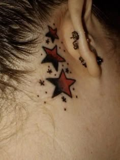 a woman's behind the ear tattoo with stars on her left side and in the middle