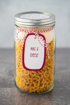 macaroni and cheese in a glass jar with a tag on the lid that says mac & cheese