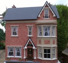 a doll house is shown in front of some bushes