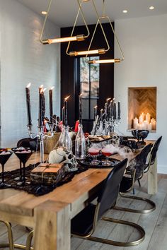 a dining room table with candles, wine glasses and other items on top of it