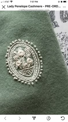 a close up of a person's green shirt with embroidered flowers on the front