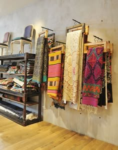 a room filled with lots of different types of fabrics hanging on the wall next to each other