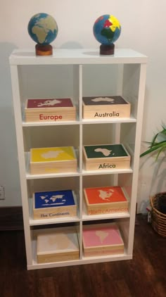 a book shelf with several different books on it and a small globe in the corner