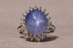 a ring with a large blue stone surrounded by small white and clear stones on it