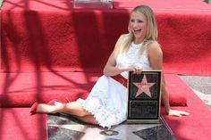 a woman sitting on the hollywood walk of fame