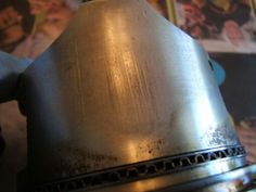 a close up of a metal object on a table with comic books in the background