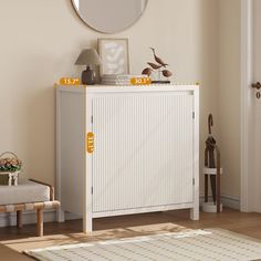 a white cabinet sitting in the corner of a room with a mirror on top of it