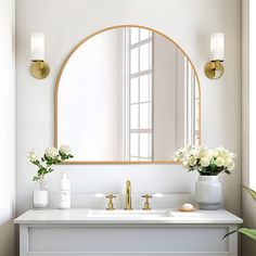 a bathroom vanity with a mirror, vase and flowers on the counter top in front of it