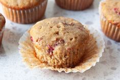 muffins with cranberry filling sitting on top of a white tablecloth